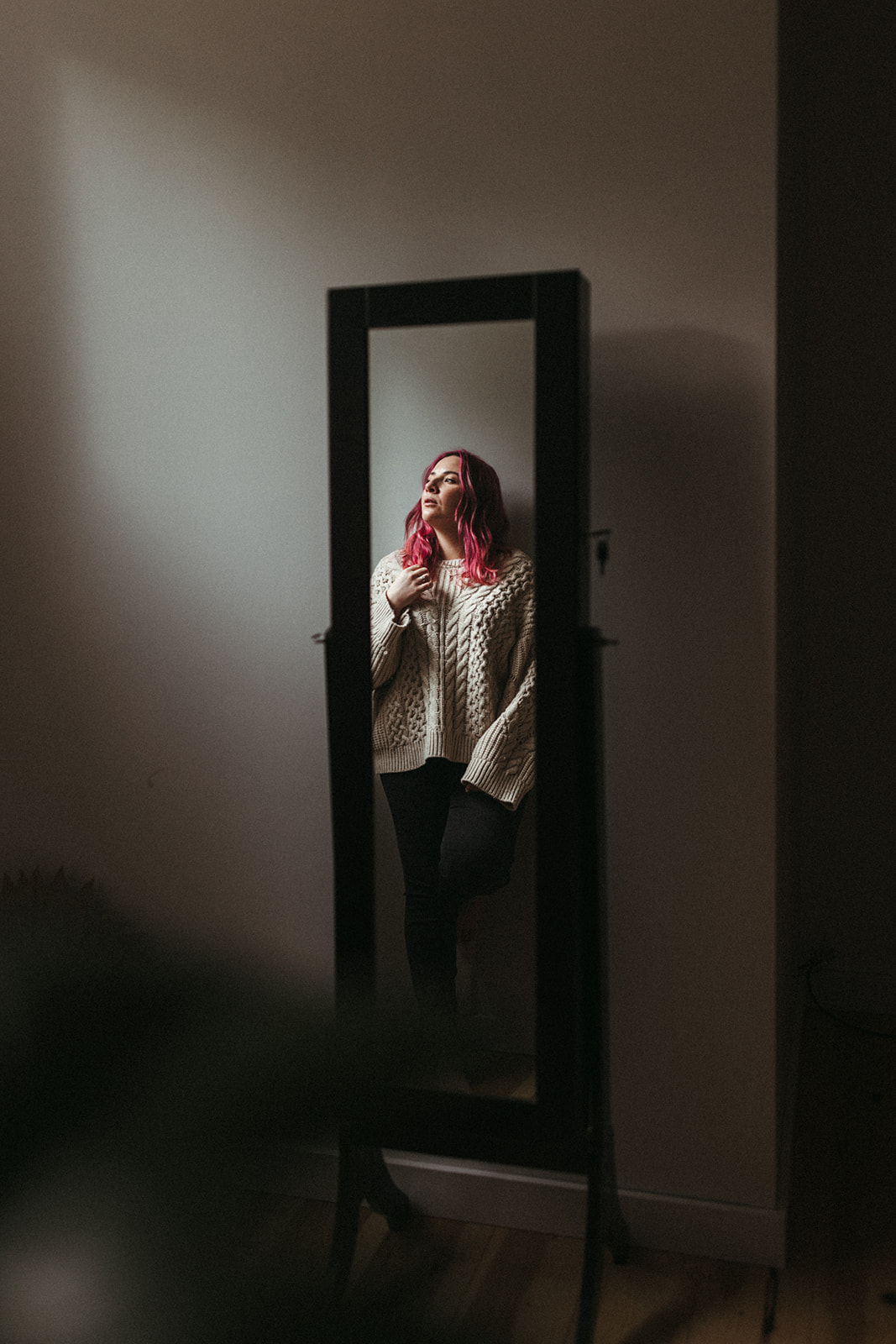 Girl with pink hair reflected in a full length mirror